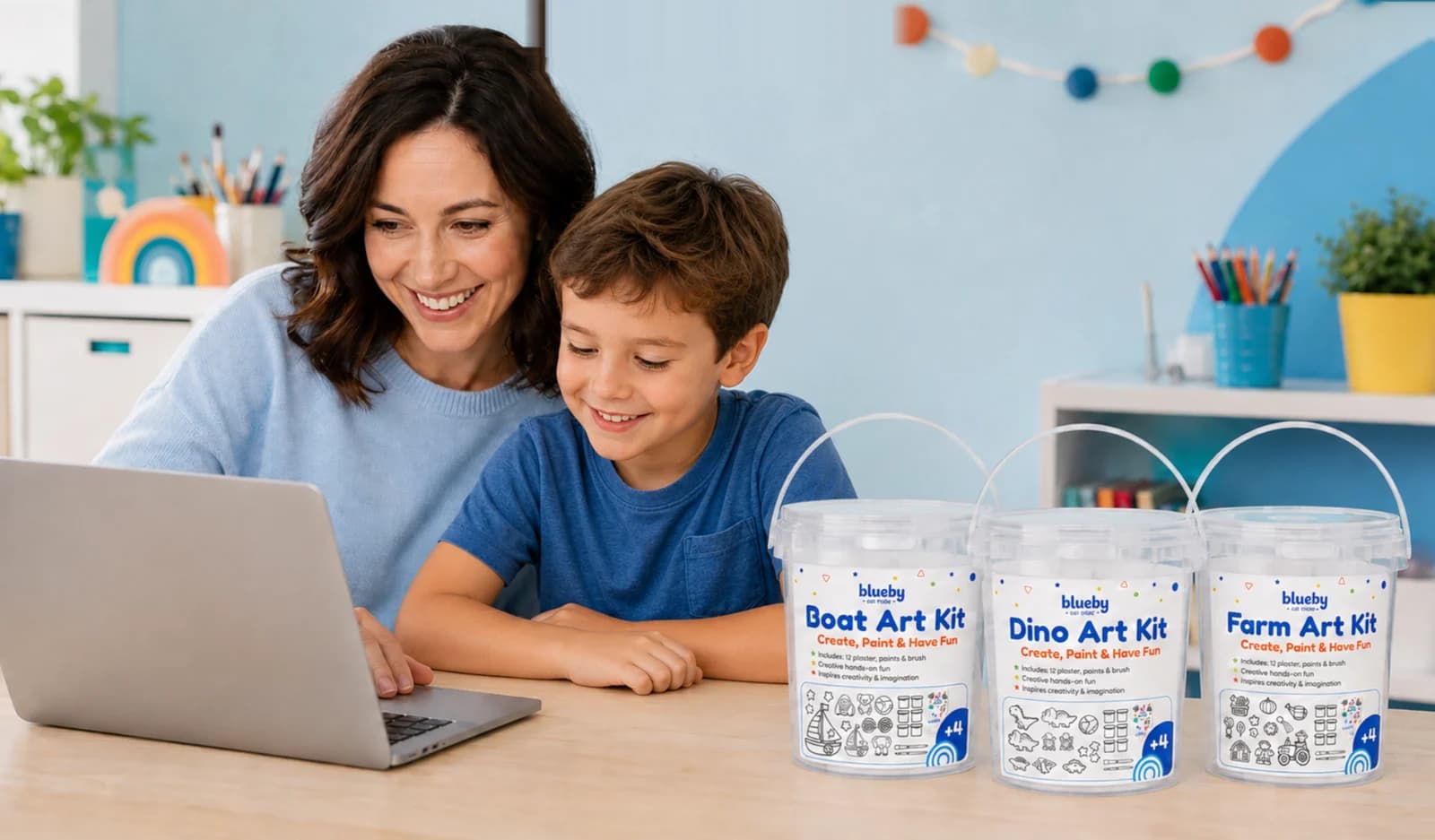 A mother and her son at a laptop with three Blueby Bear Art Kit buckets on the desk
